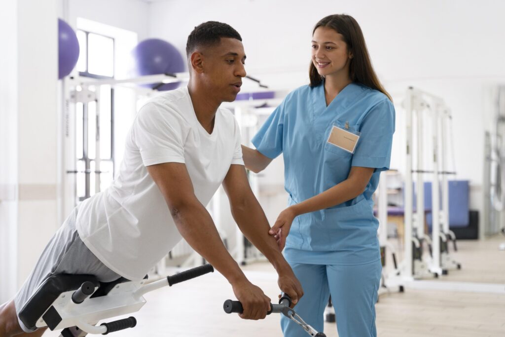 Therapist guiding a patient through an exercise on rehabilitation equipment
